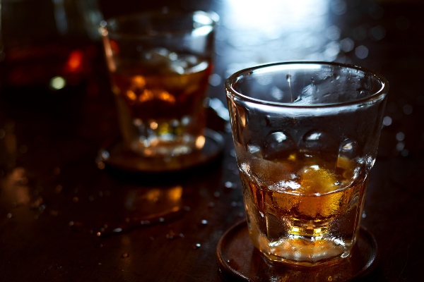 Whiskey glass on dirt bar top