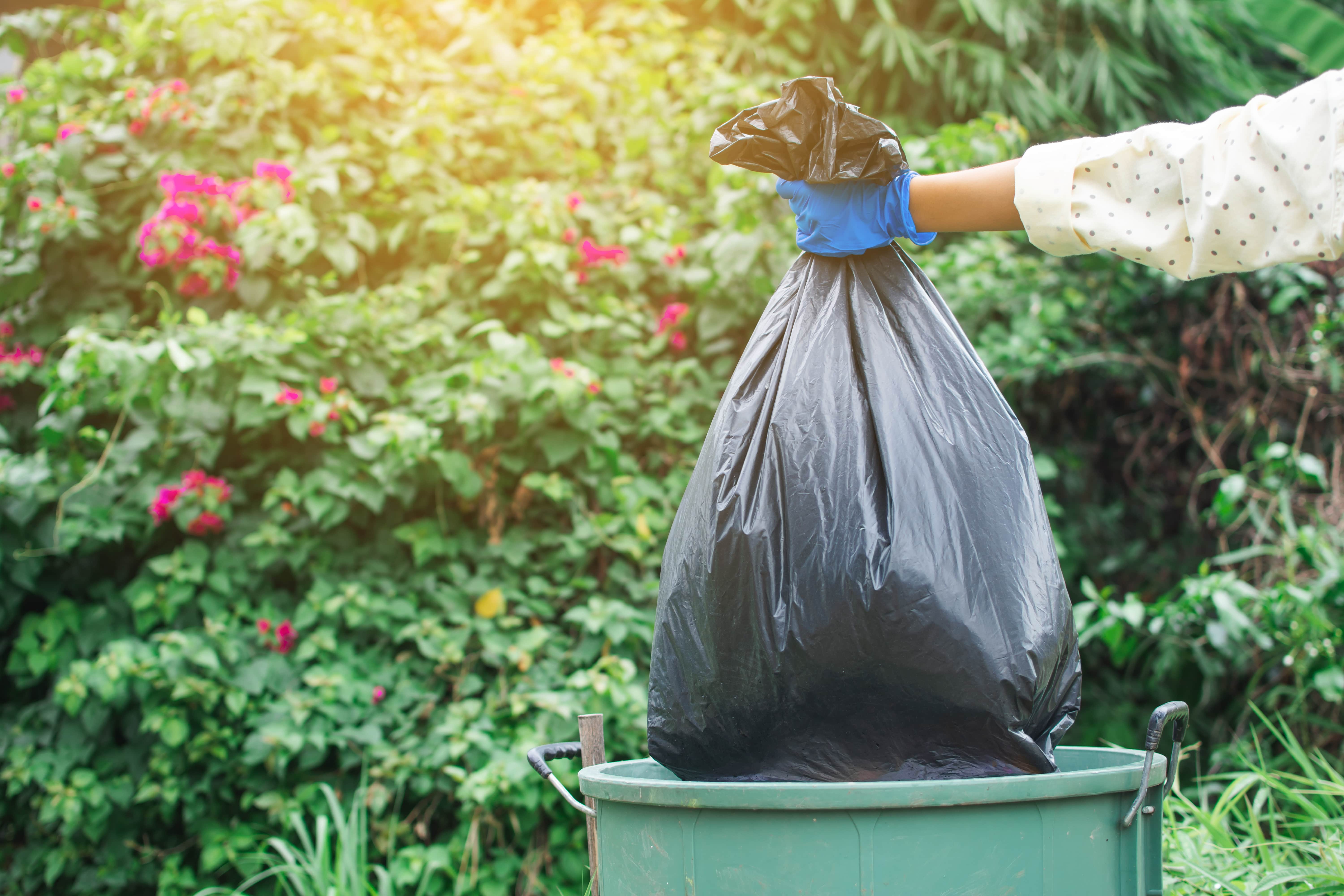 black trash bag being thrown out