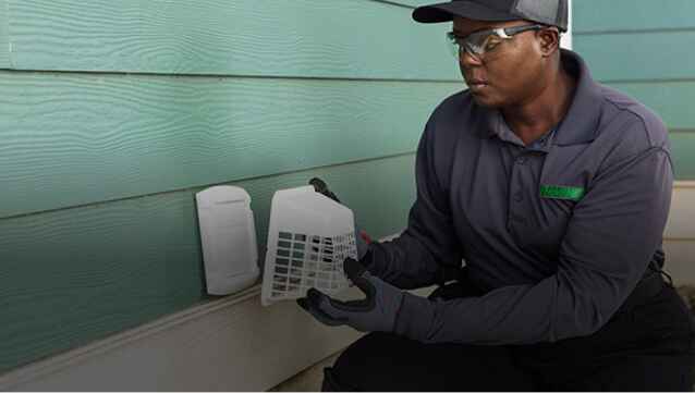 Terminix technician installing vent cover