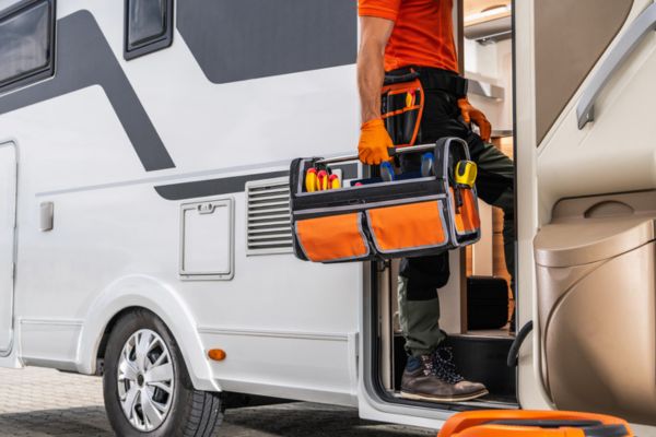 technician with tool getting on a camper