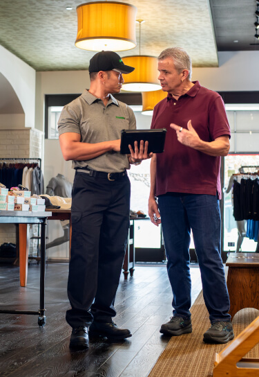 Terminix tech consults with retail store owner inside store
