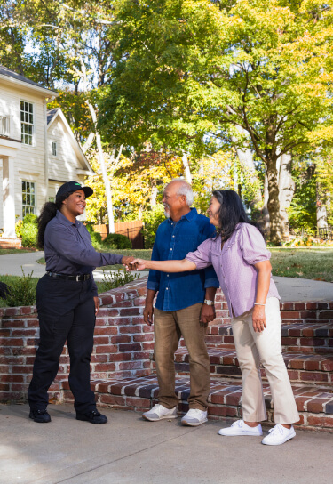 Terminix technician shaking hands with home owners