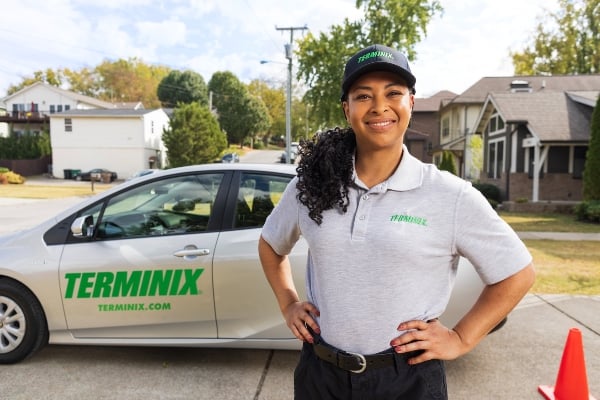 Terminix technician in front of a car